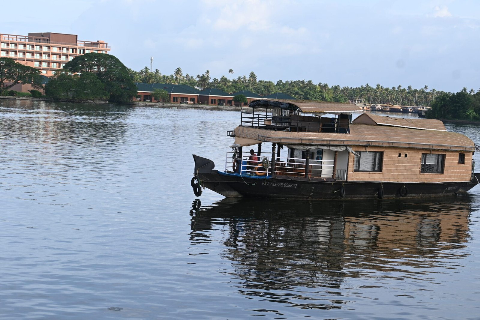 Kerala houseboat on calm backwater palm trees Alleppey