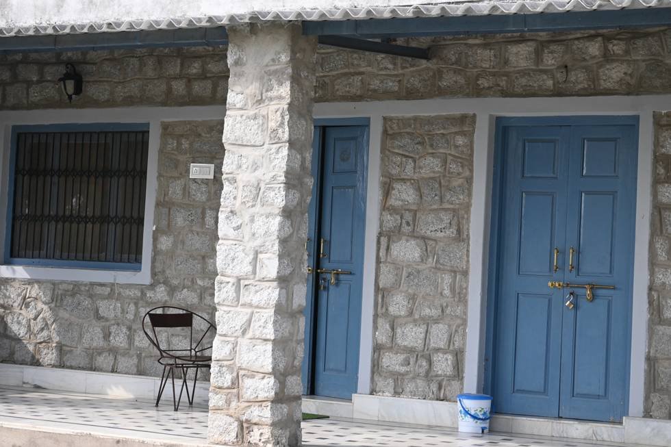 Stone cottage rooms with blue wooden doors at Jawai Manohar Vilas